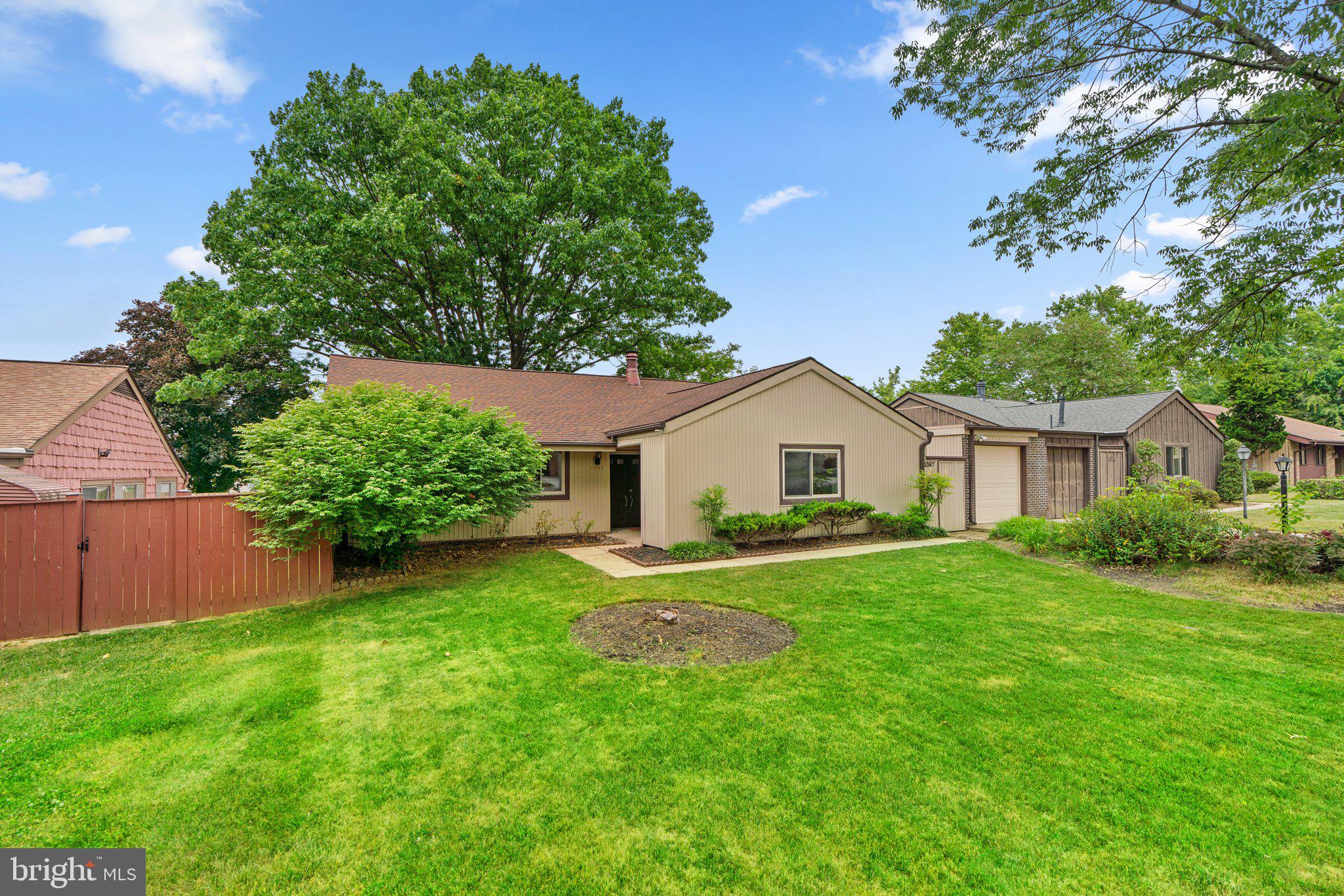 a front view of a house with a yard and trees