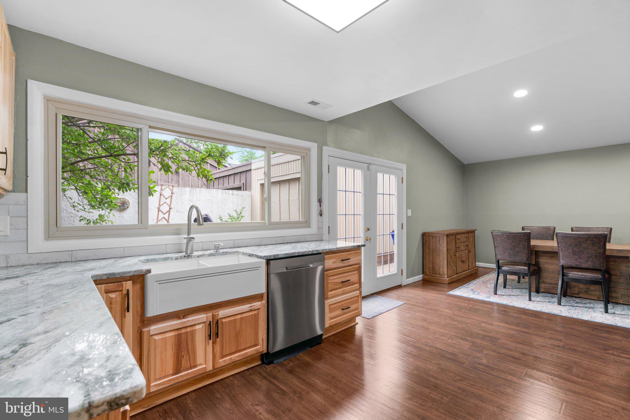 5367 Flight Feather Columbia, MD 21045 - Photo 5 of 42 a kitchen with stainless steel appliances granite countertop wooden floors and white cabinets