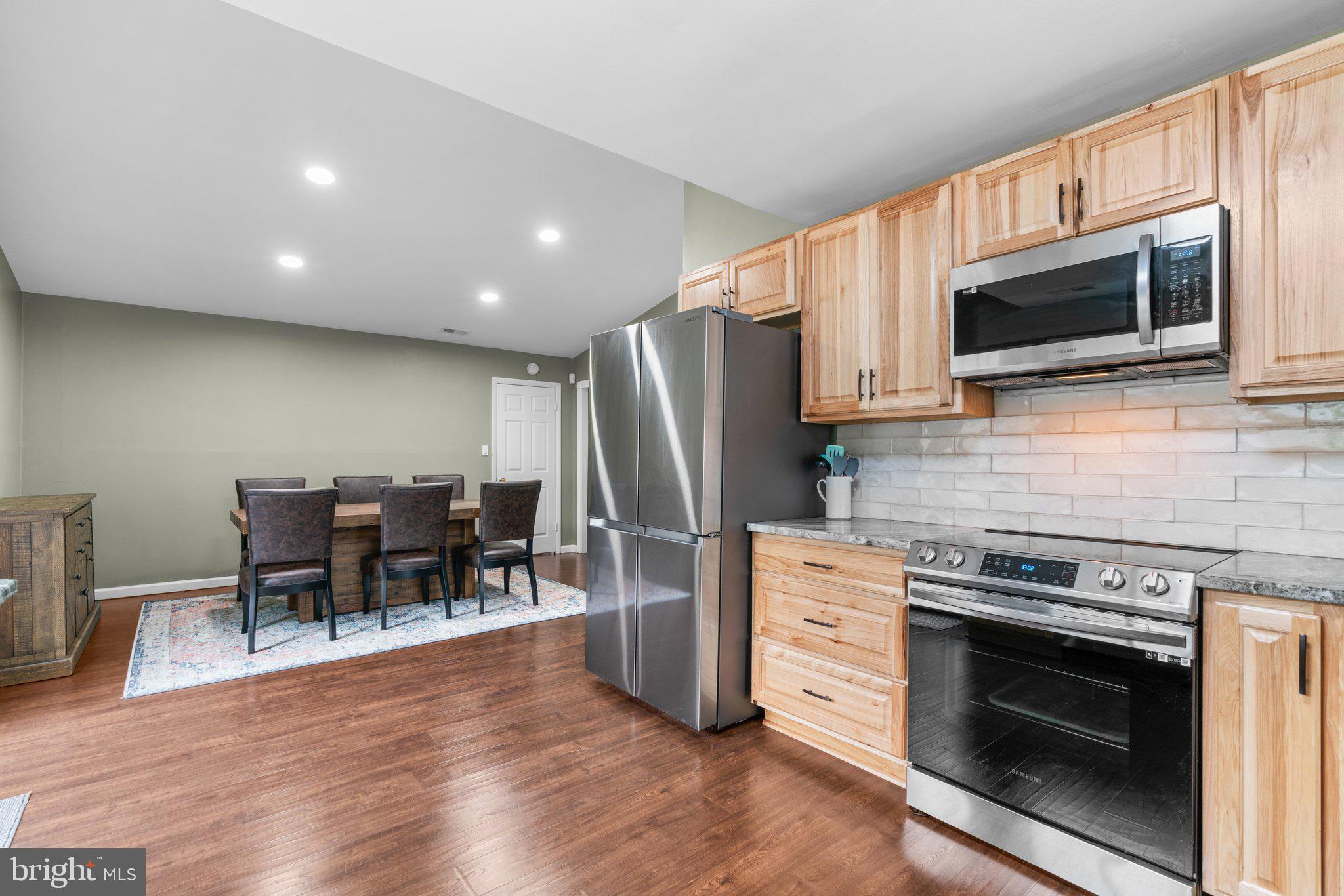 5367 Flight Feather Columbia, MD 21045 - Photo 6 of 42 a kitchen with stainless steel appliances a stove a microwave a refrigerator a stove a dining table and chairs