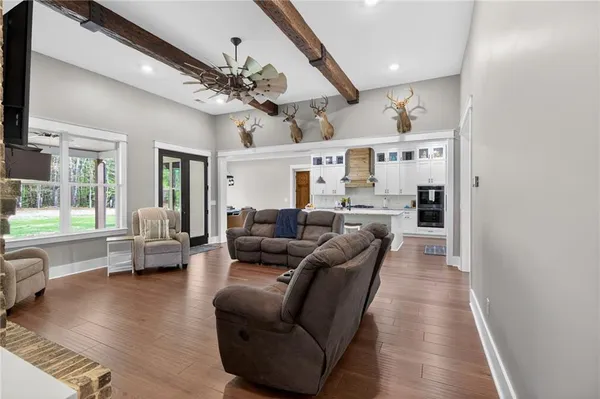 a kitchen with stainless steel appliances granite countertop a table chairs sink and cabinets