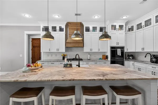 a kitchen with stainless steel appliances a sink a stove a refrigerator cabinets and living room view