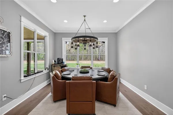 a kitchen with stainless steel appliances granite countertop a sink a stove a refrigerator and white cabinets with wooden floor