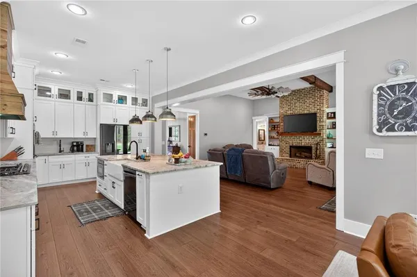 a large kitchen with sink a counter top space and living room view