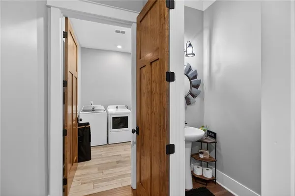 a bathroom with a double vanity sink a large mirror a bathtub and next to a window