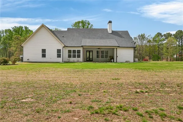 a view of a house with pool and chairs