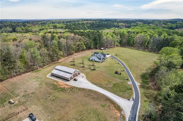 a front view of house with yard and trees in the background