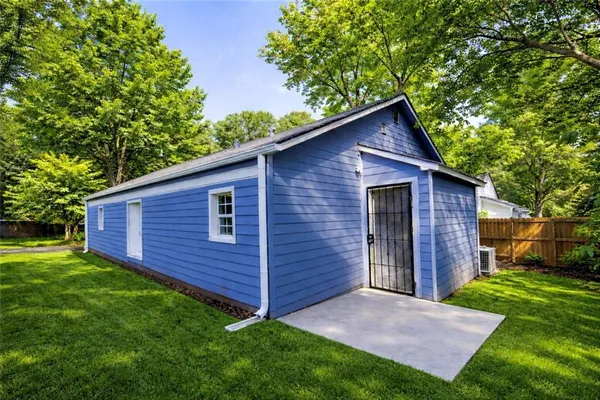 a view of a backyard with wooden fence and large trees