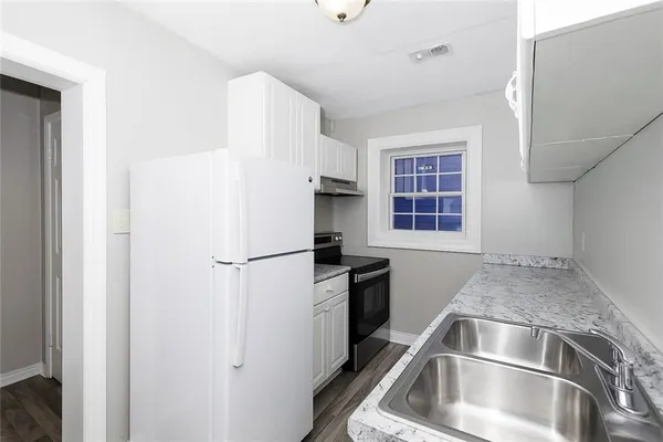 a kitchen with a refrigerator and a sink