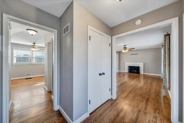 a view of a hallway with wooden floor and a living room