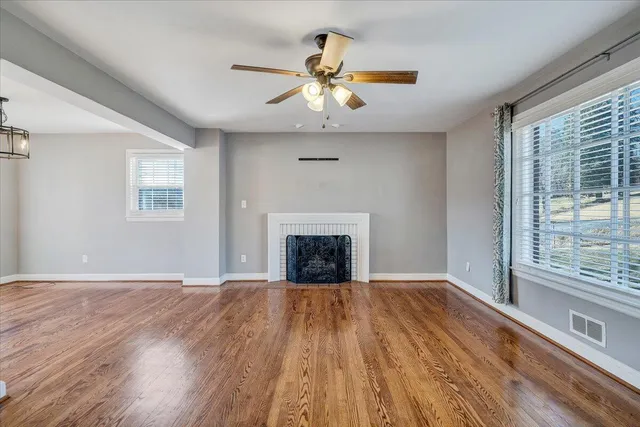 a view of an empty room with a window and a kitchen