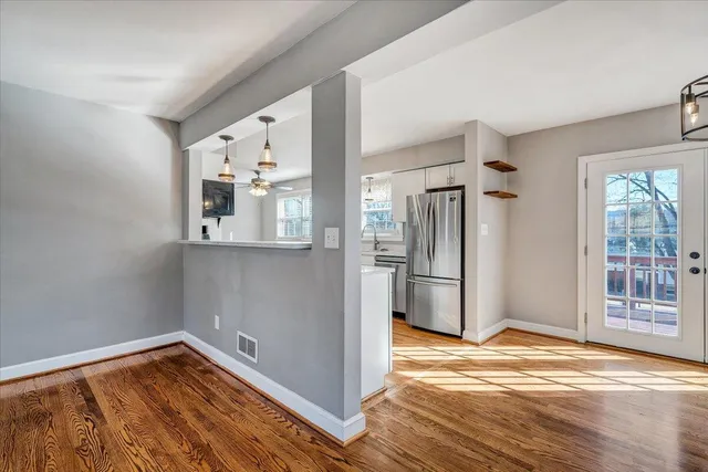 a view of an empty room with window wooden floor and fire place