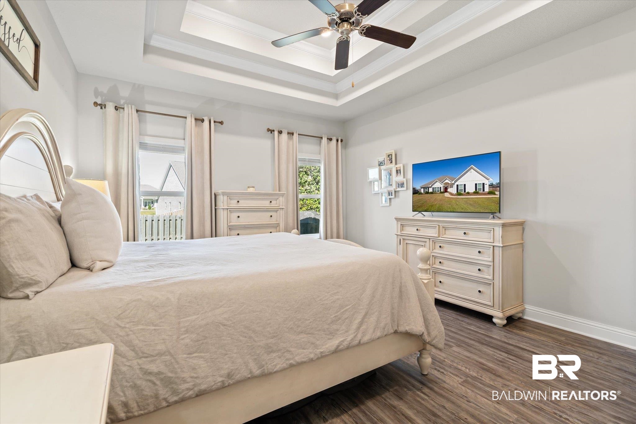 12899 Sanderling Loop Daphne, AL 36527 - Photo 15 of 28 Bedroom featuring dark wood-type flooring, ceiling fan, ornamental molding, and a tray ceiling