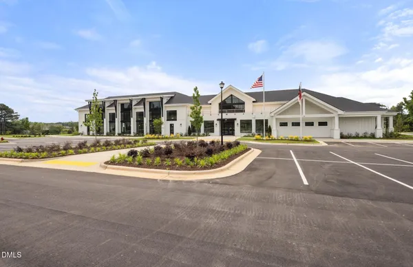 a view of a white house with a swimming pool and a yard