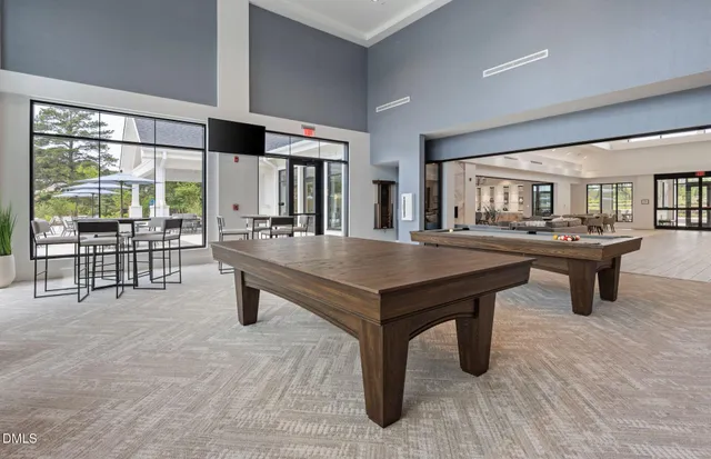 a room with stainless steel appliances kitchen island granite countertop a table chairs sink and cabinets