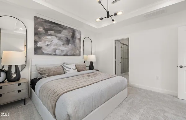 a spacious bedroom with a large bed and a chandelier