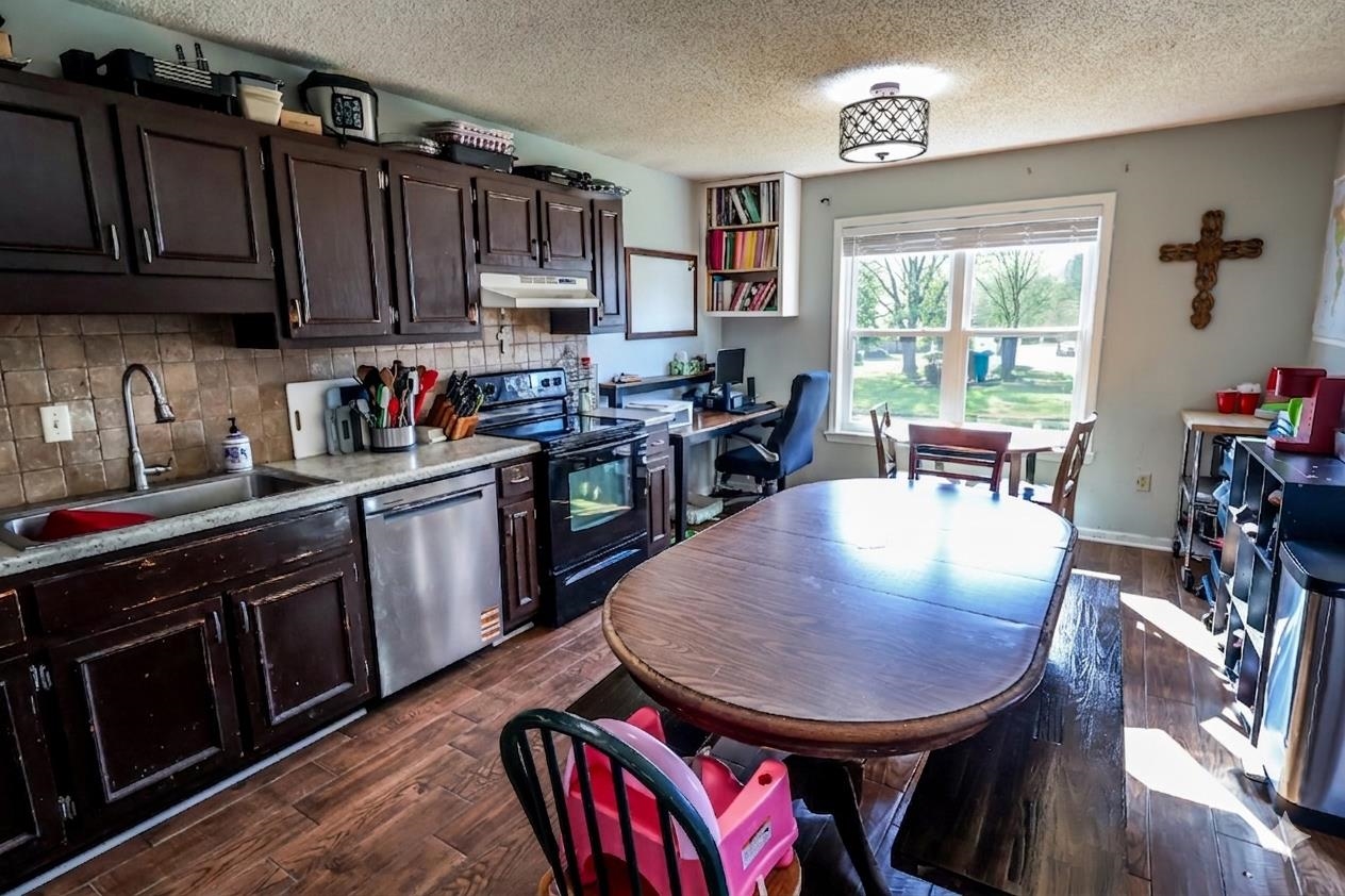 157 Nancye Reeder Avenue Munford, TN 38058 - Photo 8 of 17 a kitchen with a stove a sink dishwasher a dining table and chair with wooden floor