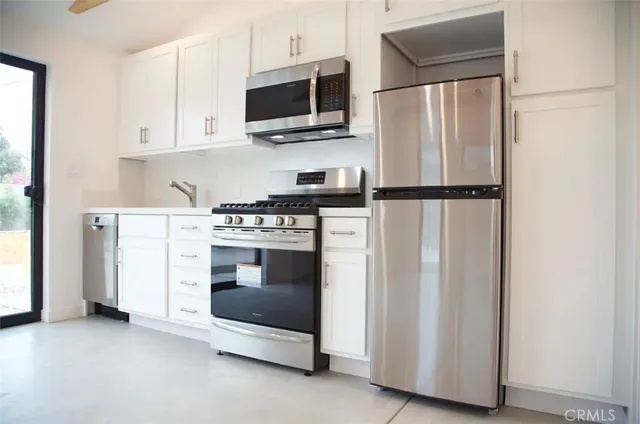 a kitchen with stainless steel appliances a refrigerator stove and microwave