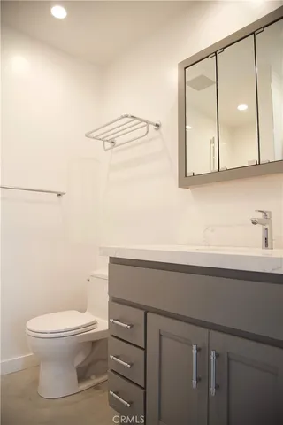 a bathroom with a toilet a sink and mirror