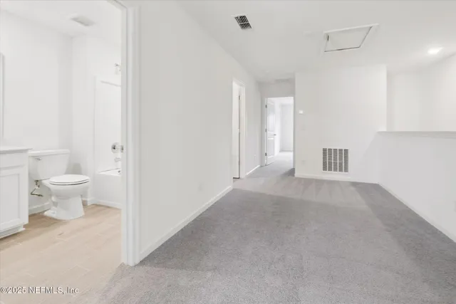 a view of a hallway with toilet and a window