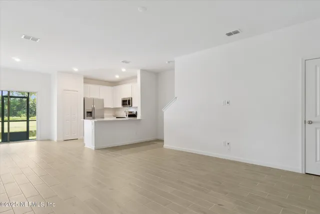 a view of a kitchen with kitchen island and stainless steel appliances