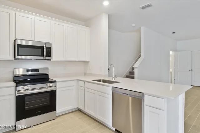 a kitchen with a sink stove and microwave