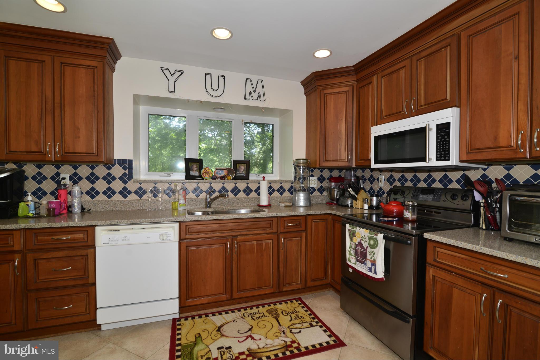 2065 Golf Course Drive Reston, VA 20191 - Photo 11 of 30 a kitchen with stainless steel appliances granite countertop a sink stove and cabinets