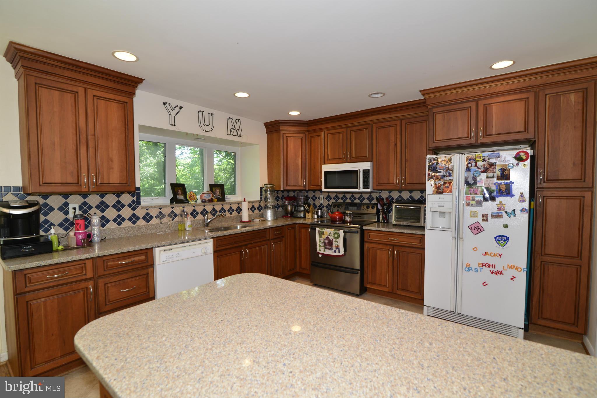 2065 Golf Course Drive Reston, VA 20191 - Photo 6 of 30 a kitchen with stainless steel appliances a refrigerator sink and cabinets