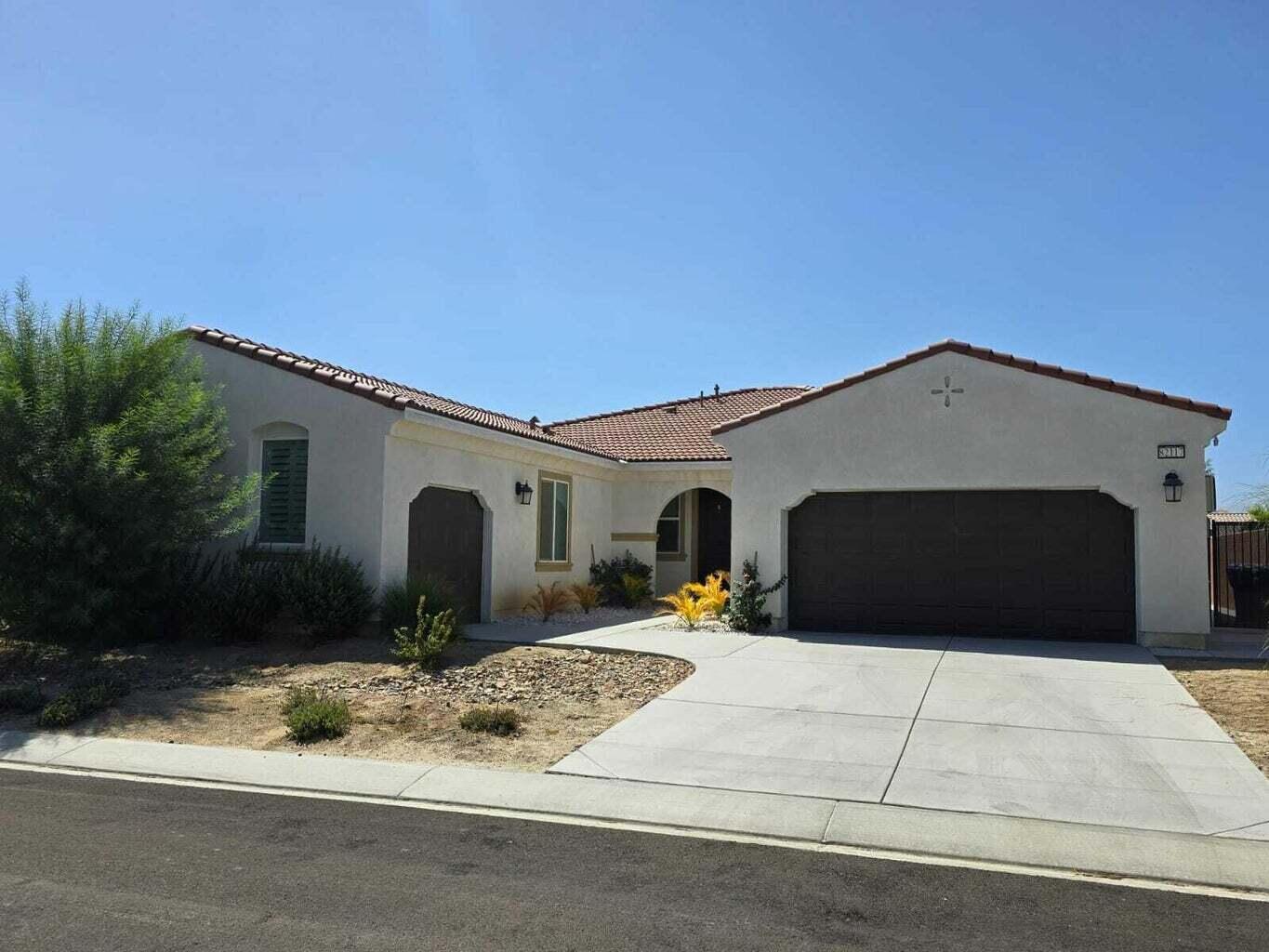 82117 Verdi Road Indio, CA 92203 - Photo 1 of 24 a front view of a house with a yard and garage
