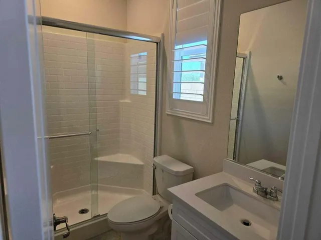 a bathroom with a granite countertop sink toilet and shower
