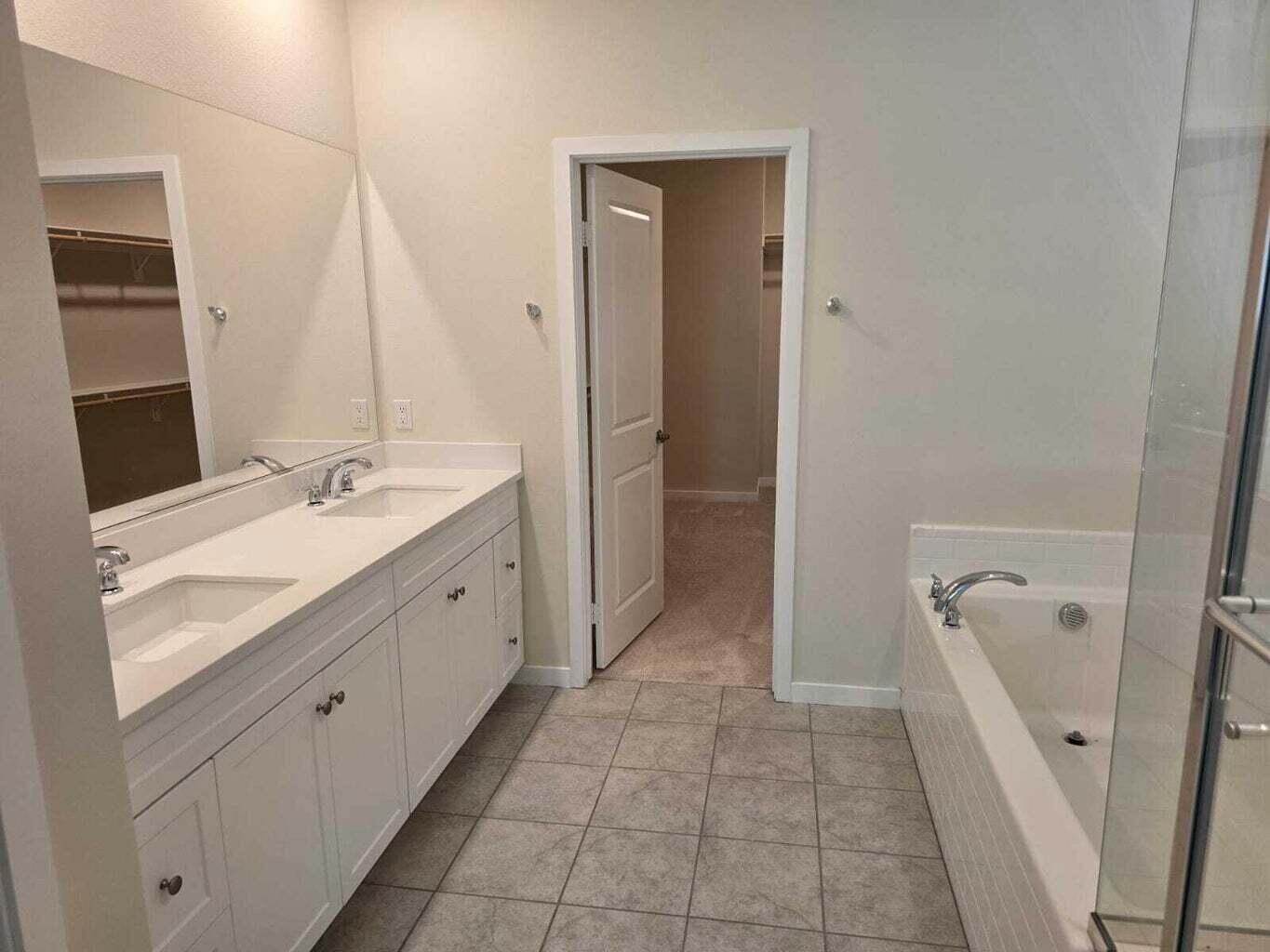 82117 Verdi Road Indio, CA 92203 - Photo 20 of 24 a spacious bathroom with a granite countertop sink a mirror and a bathtub