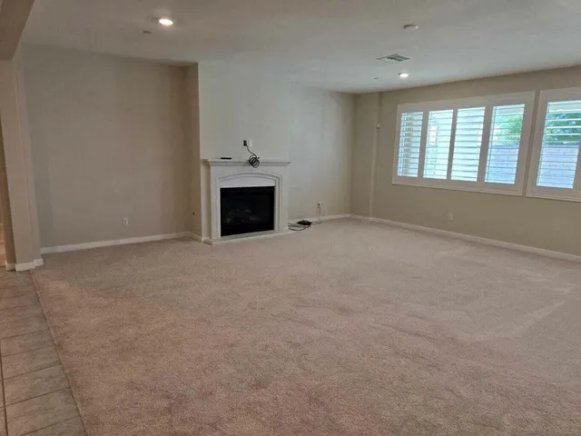 an empty room with fireplace and windows