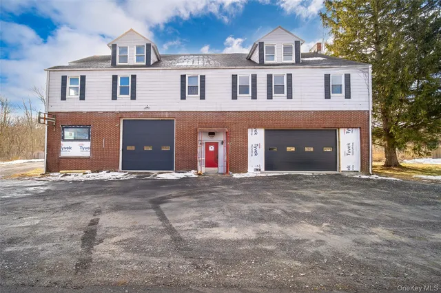 a front view of a house with a yard and a garage