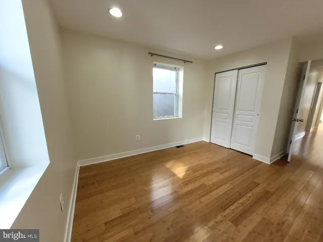 an empty room with wooden floor and closet