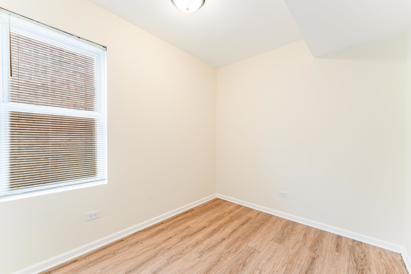 5025 West Huron Street, Unit 2 Chicago, IL 60644 - Photo 11 of 20 a view of empty room with wooden floor and fan