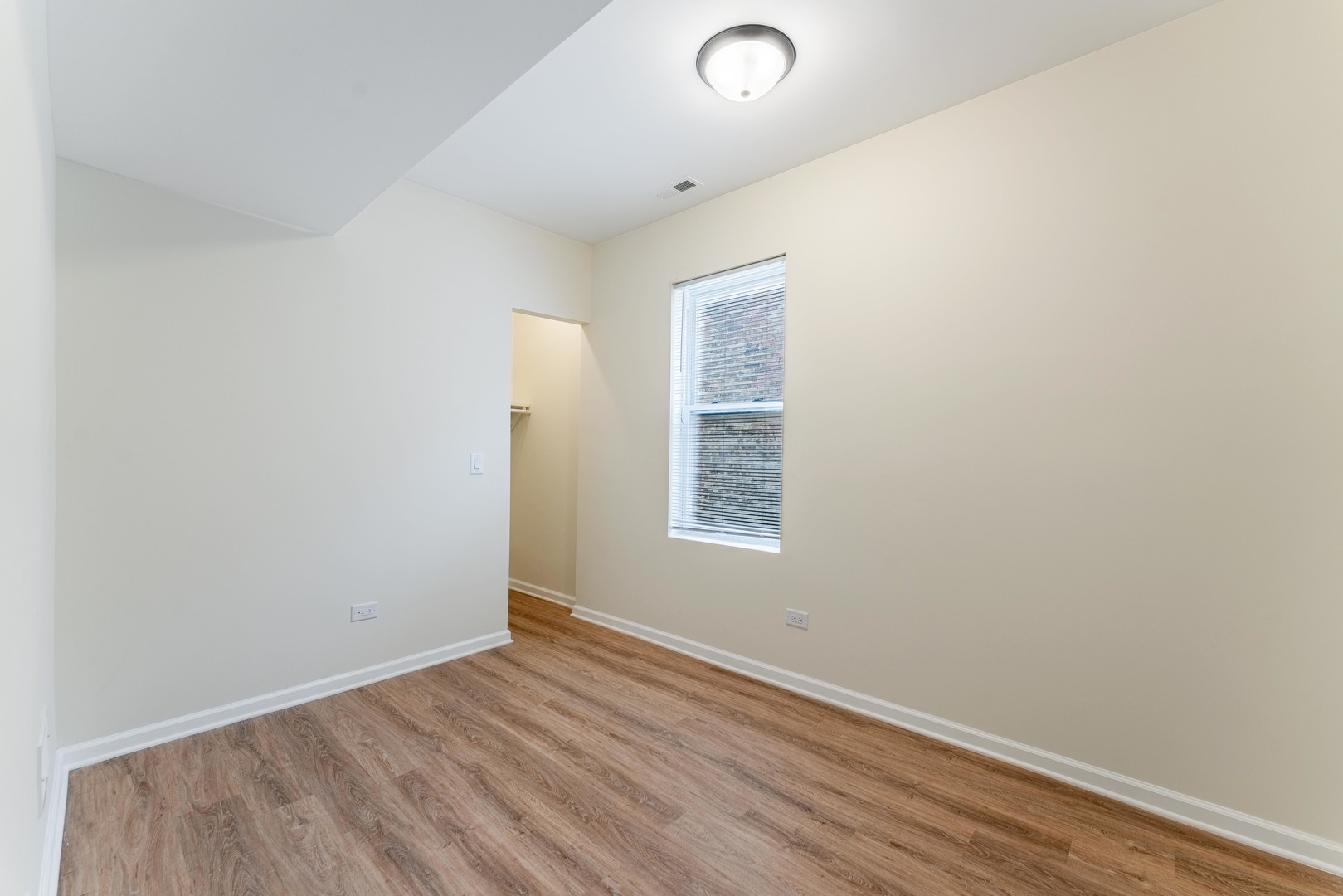 5025 West Huron Street, Unit 2 Chicago, IL 60644 - Photo 15 of 20 an empty room with wooden floor and windows