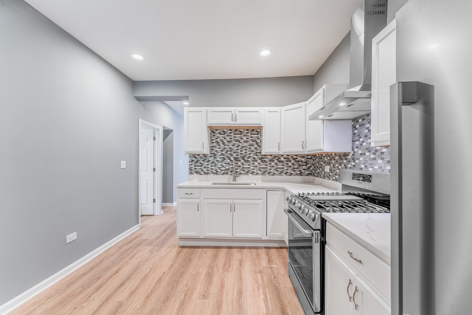5025 West Huron Street, Unit 2 Chicago, IL 60644 - Photo 20 of 20 a kitchen with a stove a sink and a refrigerator