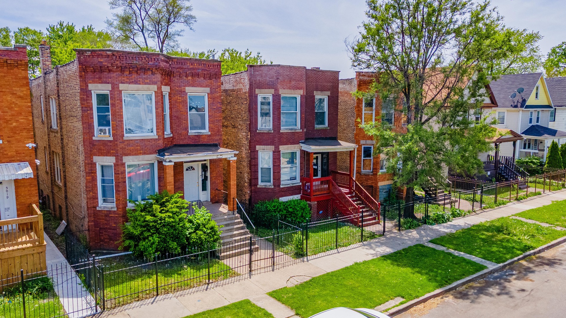 5025 West Huron Street, Unit 2 Chicago, IL 60644 - Photo 2 of 20 a front view of a residential apartment building with a yard and potted plants
