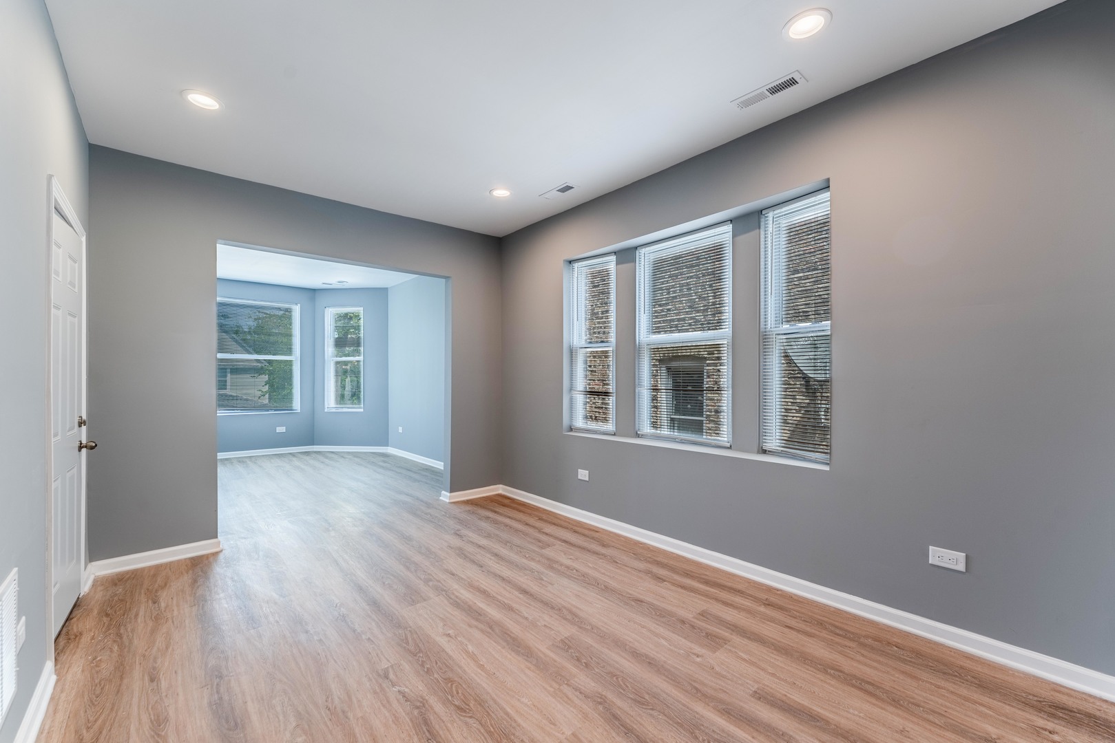 5025 West Huron Street, Unit 2 Chicago, IL 60644 - Photo 5 of 20 a view of an empty room with wooden floor and a window