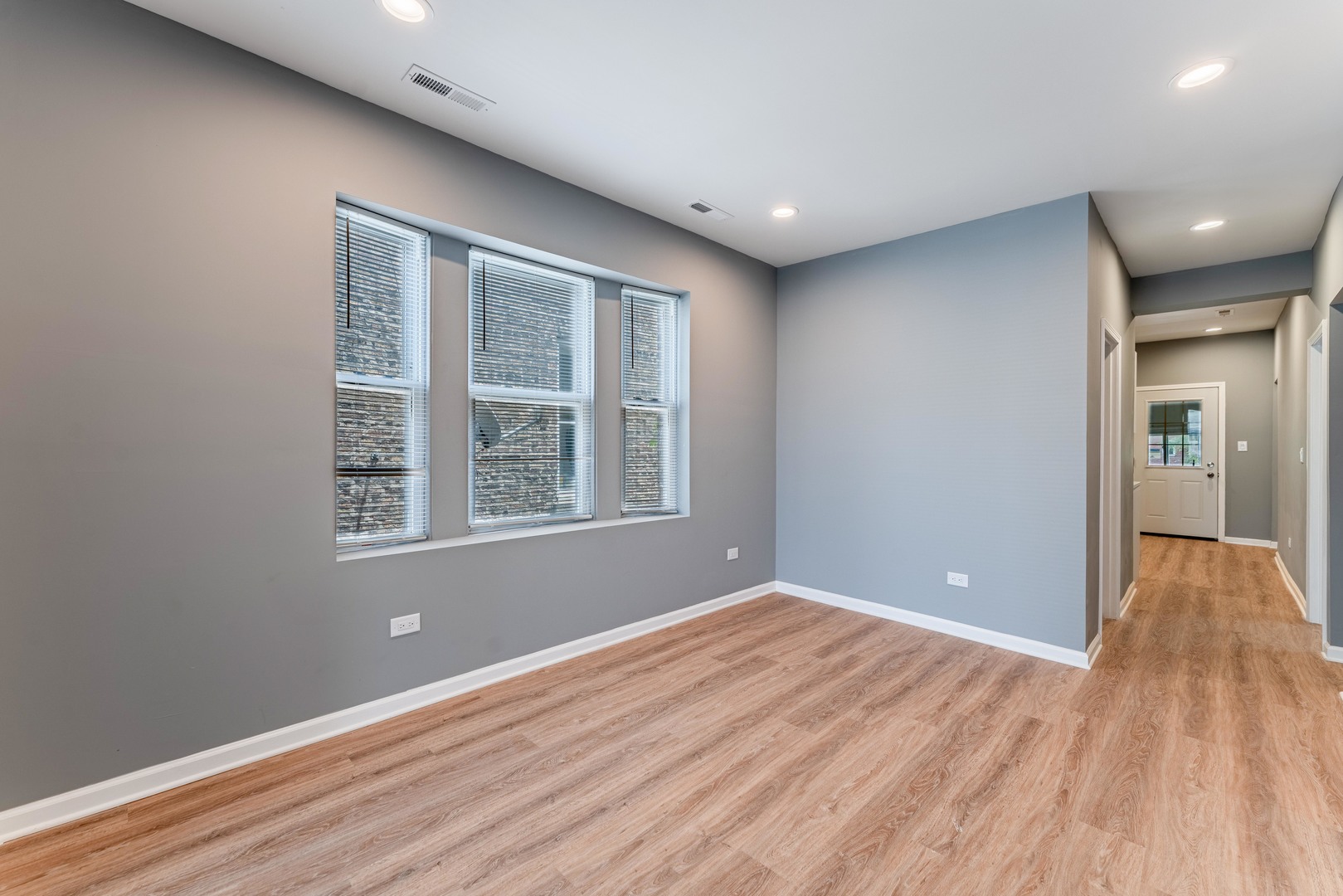 5025 West Huron Street, Unit 2 Chicago, IL 60644 - Photo 6 of 20 a view of an empty room with wooden floor and a window