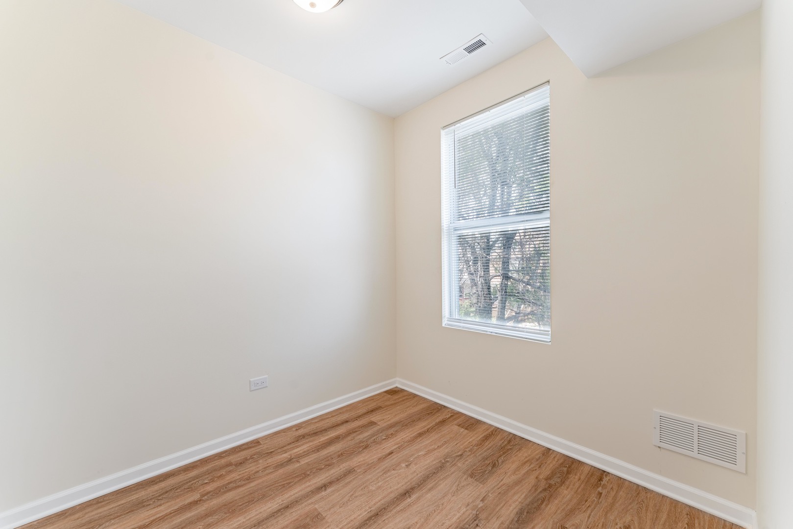 5025 West Huron Street, Unit 2 Chicago, IL 60644 - Photo 9 of 20 a view of an empty room with wooden floor and a window