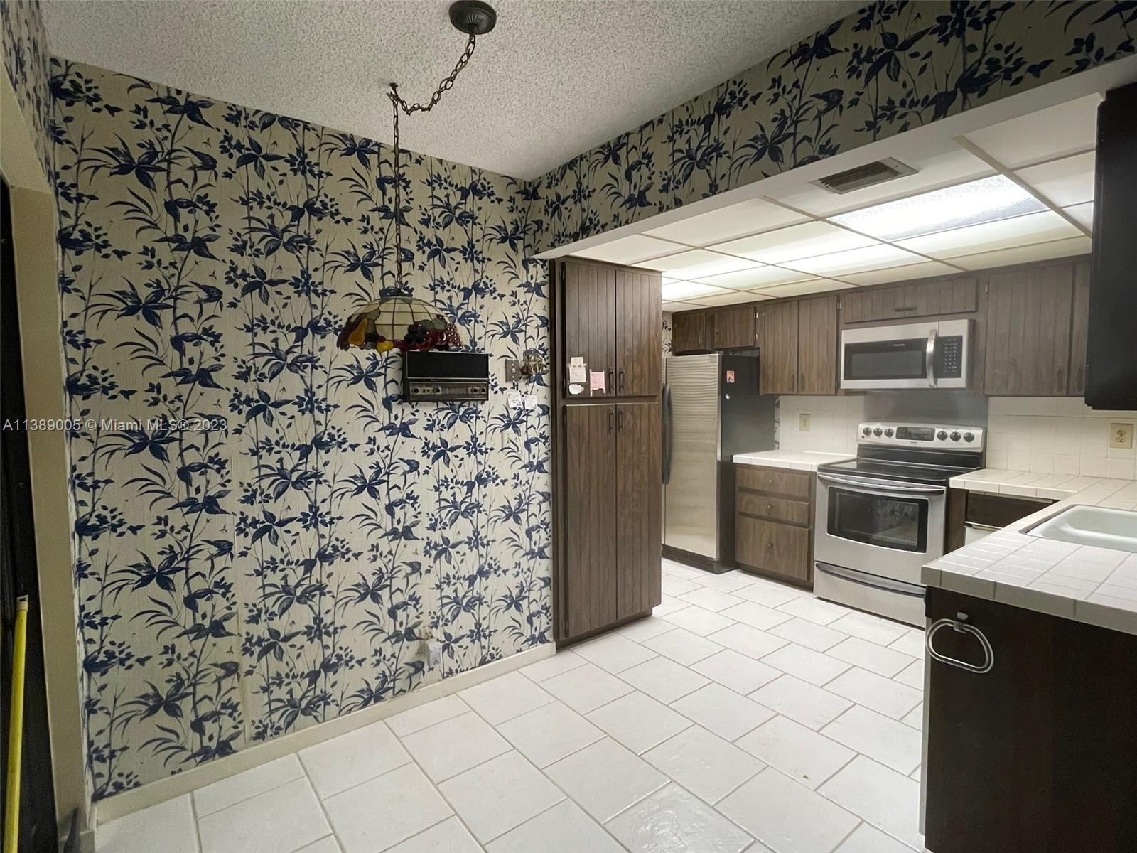 6848 Tiburon Drive Boca Raton, FL 33433 - Photo 5 of 12 a kitchen with a refrigerator and a stove top oven