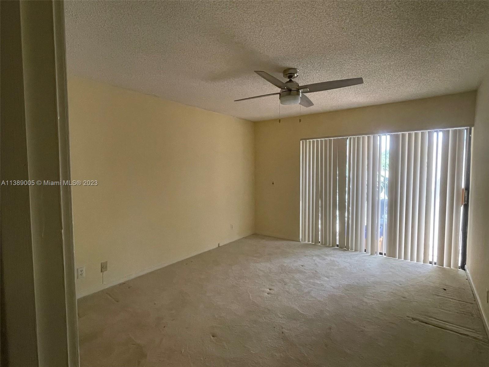6848 Tiburon Drive Boca Raton, FL 33433 - Photo 9 of 12 an empty room with windows and fan