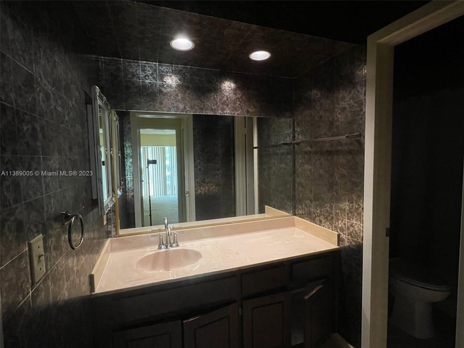 6848 Tiburon Drive Boca Raton, FL 33433 - Photo 10 of 12 a bathroom with a sink and a mirror