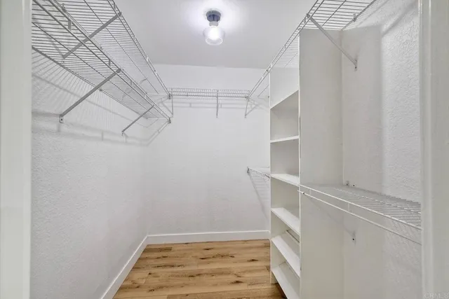 a view of walk in closet with empty racks