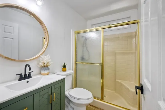 a bathroom with a sink mirror toilet and shower