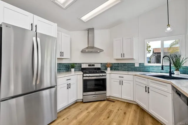 a kitchen with stainless steel appliances granite countertop a stove a refrigerator and a granite counter tops