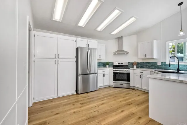 a kitchen with a refrigerator a stove top oven a sink and cabinets