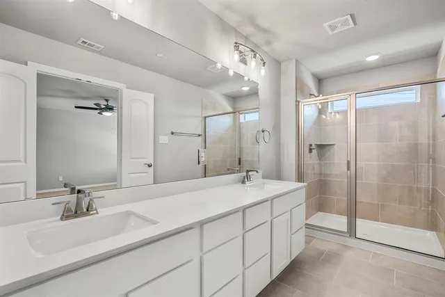 a bathroom with a double vanity sink mirror double and shower
