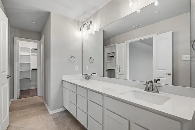 a spacious bathroom with a double vanity sink mirror and shower