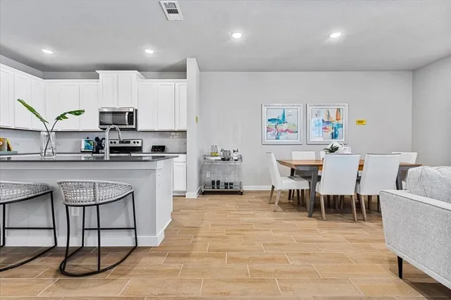 a kitchen with stainless steel appliances kitchen island granite countertop a sink and a stove top oven
